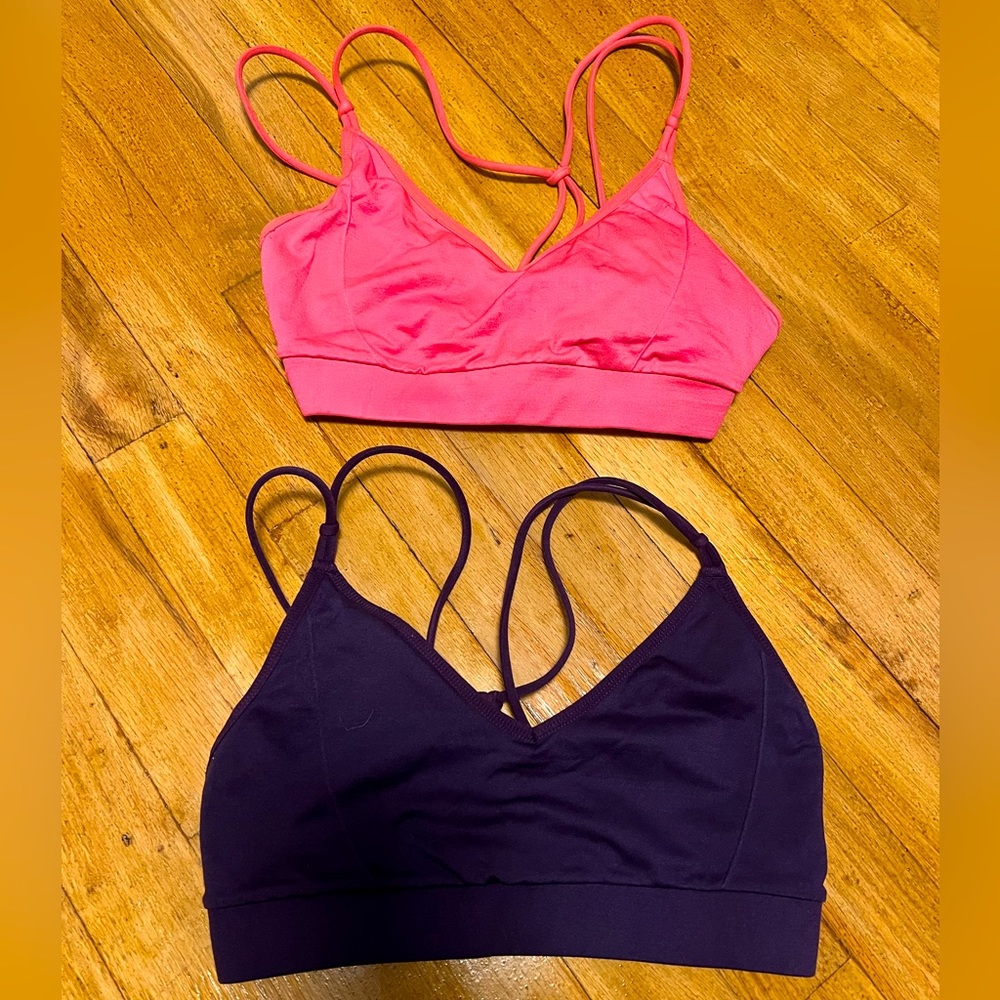Two small Fabletics sports bras. Lightly padded. One bubblegum pink, one purple